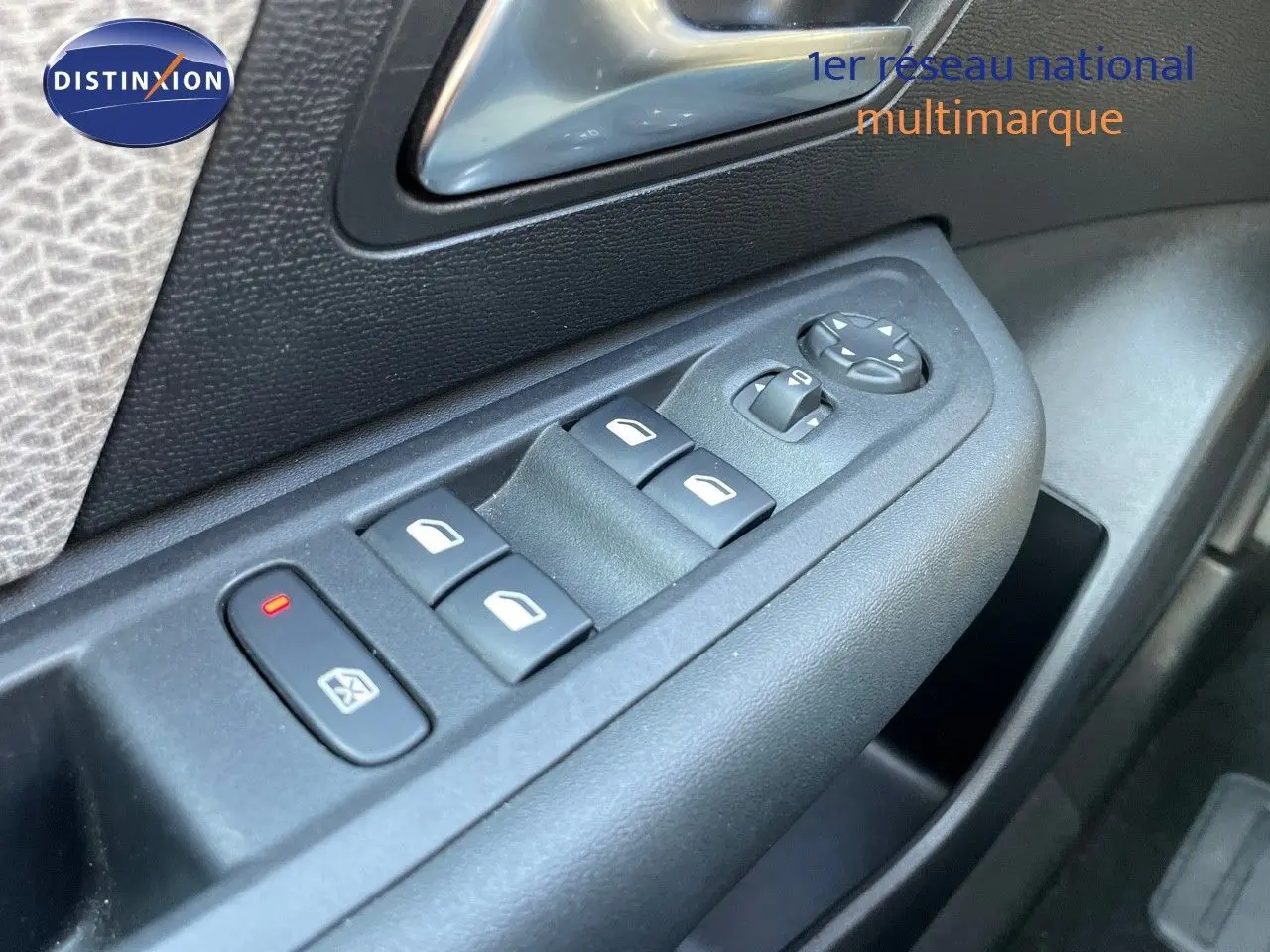 Gros plan sur les commandes des vitres électriques et rétroviseurs côté conducteur d'une Citroën C4 bleu Iceland Metal.