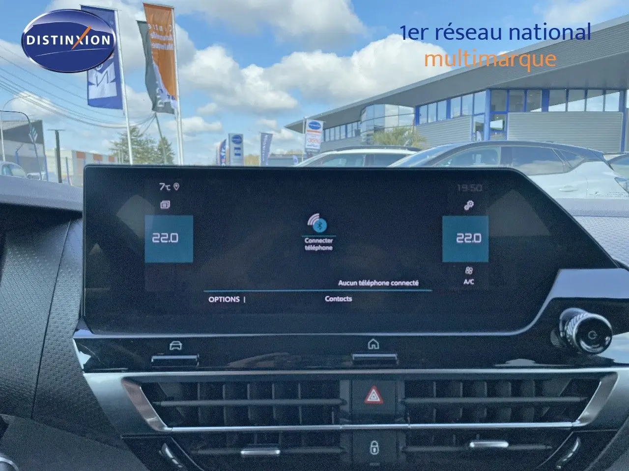 Vue intérieure centrée sur l'écran tactile du tableau de bord d'une Citroën C4 bleu Iceland Metal, avec commandes climatisation visibles.