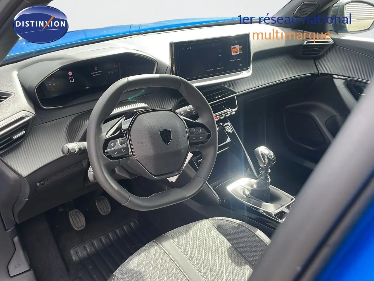 Intérieur du Peugeot 2008 2024 bleu Vertigo, vue côté conducteur sur volant, tableau de bord digital et levier de vitesse manuel.