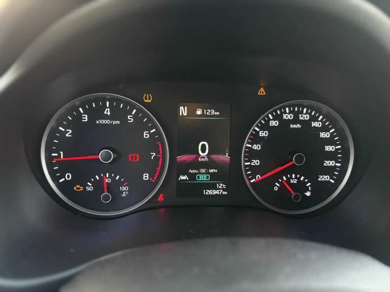 Vue rapprochée du volant noir perforé avec commandes multifonctions du KIA Stonic 2020, tableau de bord flou en arrière-plan.