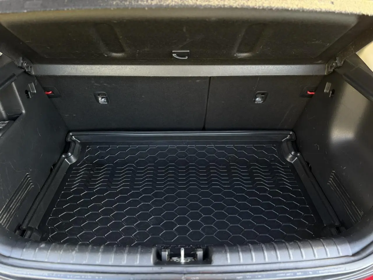 Vue 3/4 arrière droite d'un KIA Stonic rouge métallisé avec feux LED et badge eco dynamics+ visible.