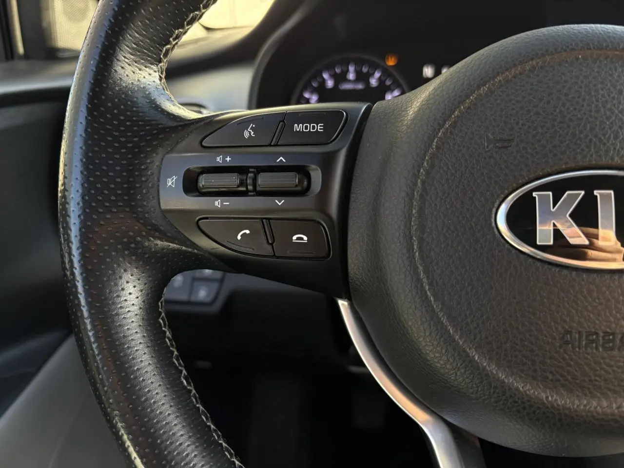 Gros plan sur la commande des vitres électriques côté conducteur du Kia Stonic rouge, avec réglage des rétroviseurs.