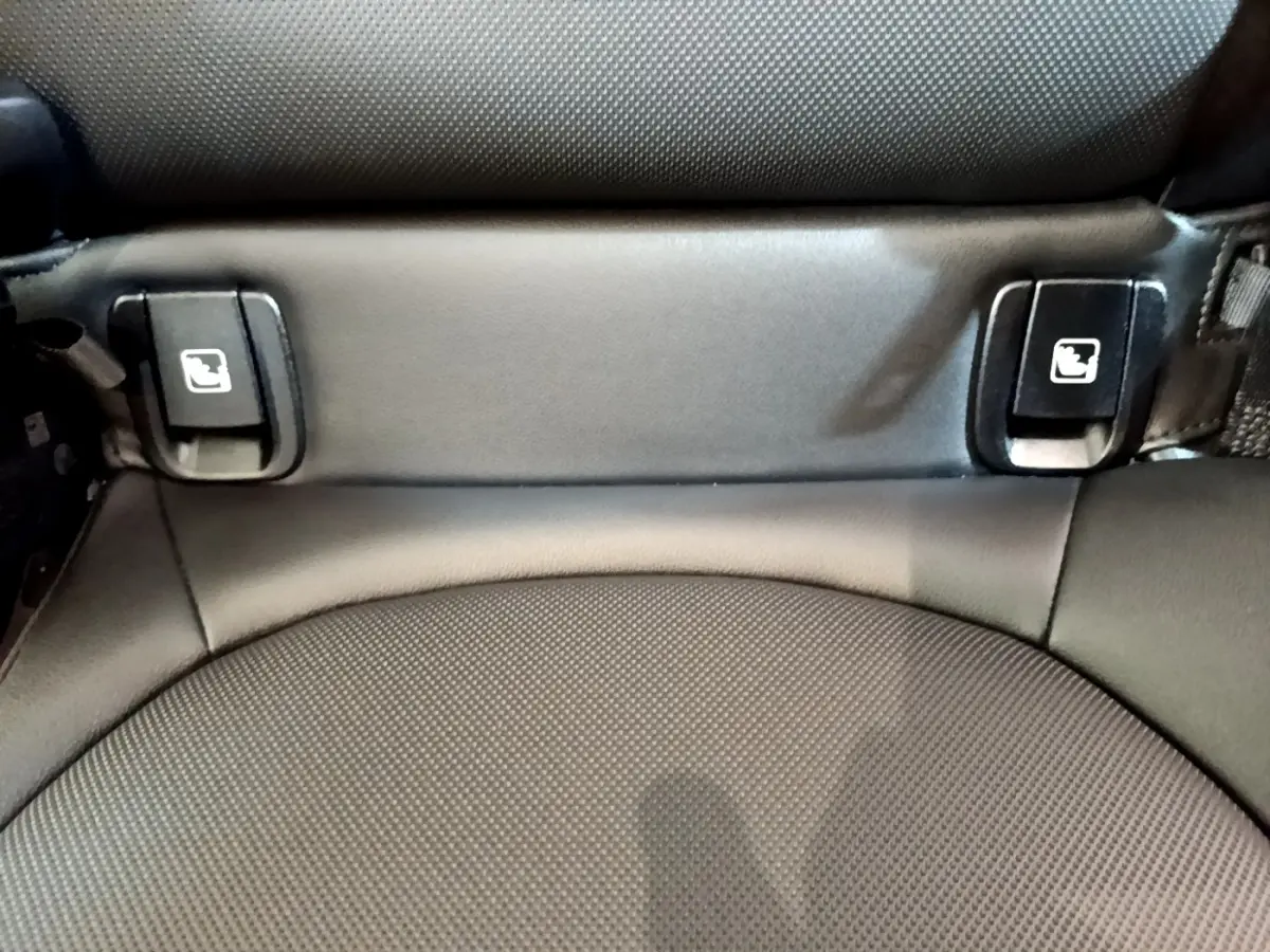 Détail des attaches Isofix noires sur siège arrière en tissu gris foncé du MINI Countryman vert hybride 2023