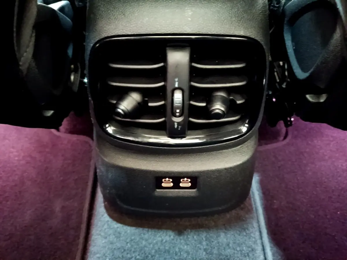 Gros plan sur la sortie d'air arrière noire et les commandes de chauffage des sièges dans un MINI Countryman vert 2023.