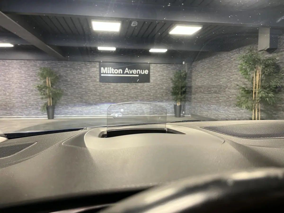 Affichage tête haute en fonctionnement sur le tableau de bord d'une Renault Mégane GT bleue, vue depuis le siège conducteur.