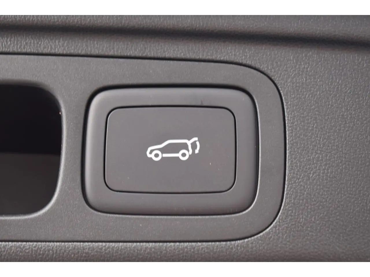 Bouton intérieur noir pour ouverture du coffre sur MG MOTOR EHS 1.5 Hybrid+ 224 ch Luxury 2026, vue en gros plan.