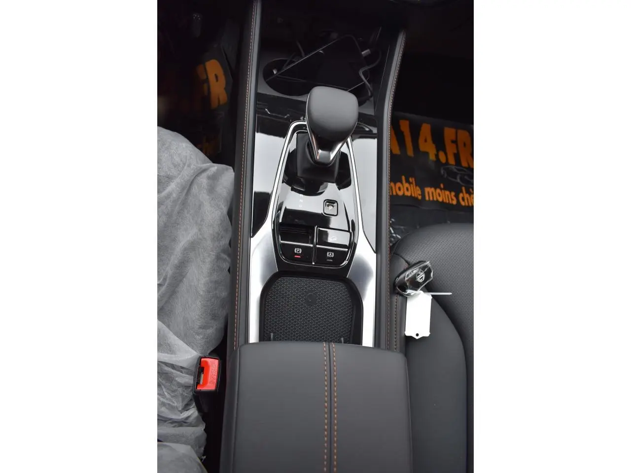 Vue plongeante sur la console centrale du MG EHS 1.5 Hybrid+ 224 ch Luxury avec levier de vitesses et clé posée sur le siège noir.