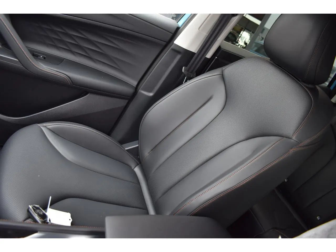 Gros plan sur le siège avant droit en cuir noir avec surpiqûres marron du MG Motor EHS 1.5 Hybrid+ 224 ch Luxury 2026.