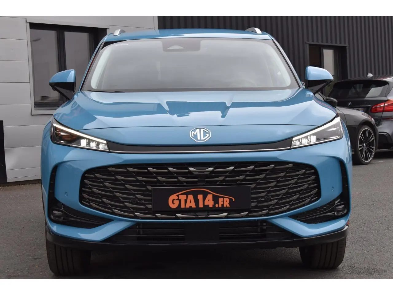 Vue frontale du MG Motor EHS 1.5 Hybrid+ 224 ch Luxury bleu 2026 avec calandre large et phares LED fins.