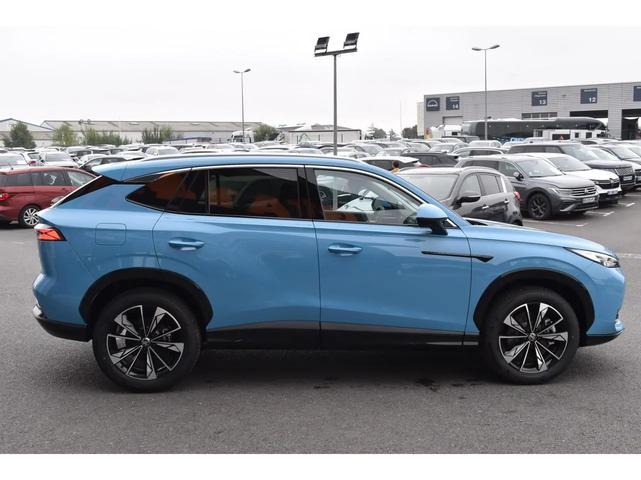 Vue de profil côté gauche du MG MOTOR EHS 1.5 Hybrid+ 224 ch Luxury bleu avec jantes noires et détails noirs contrastants.