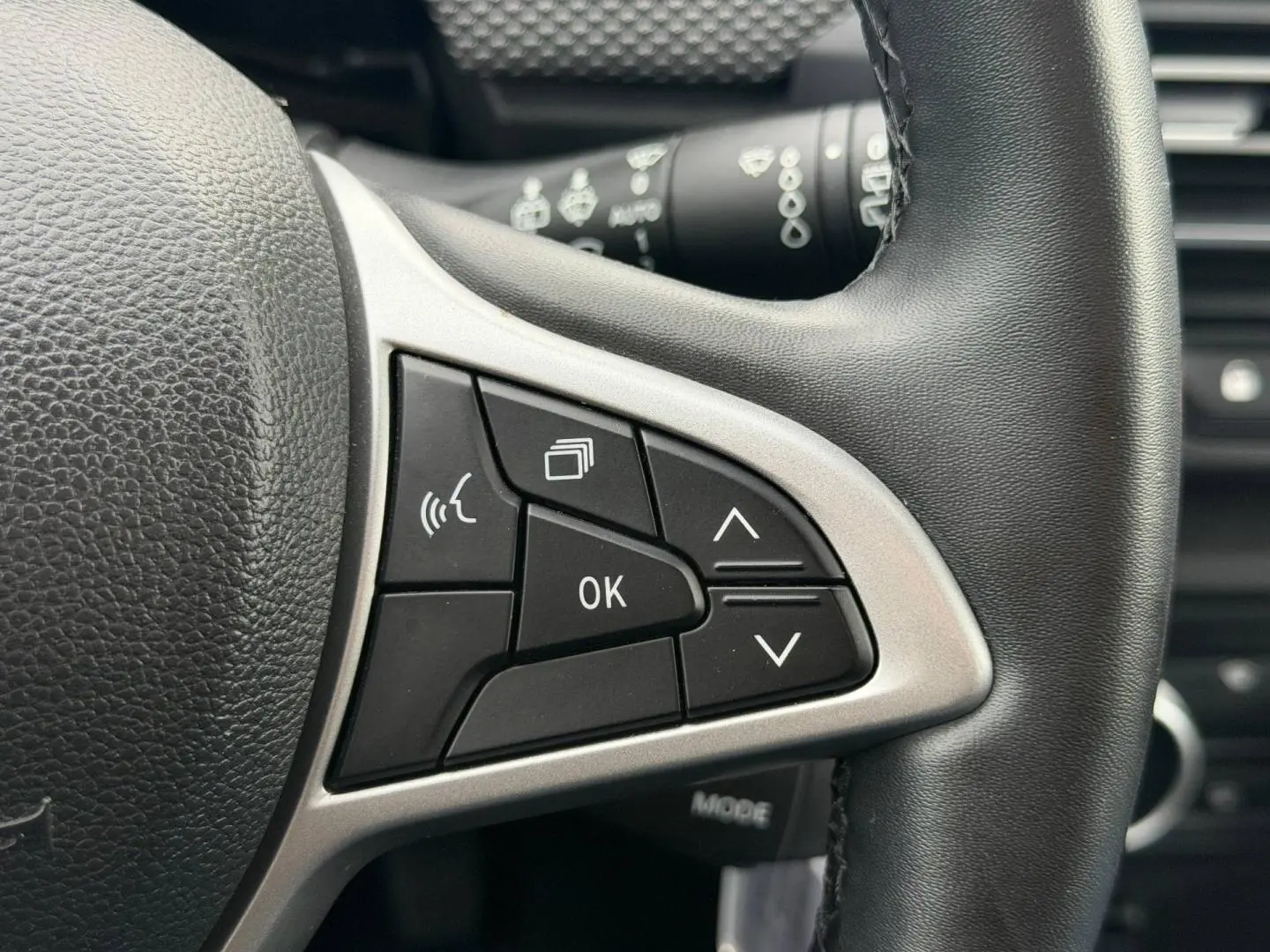 Gros plan sur les commandes multifonctions noires et argentées du volant du Dacia Jogger 2025.