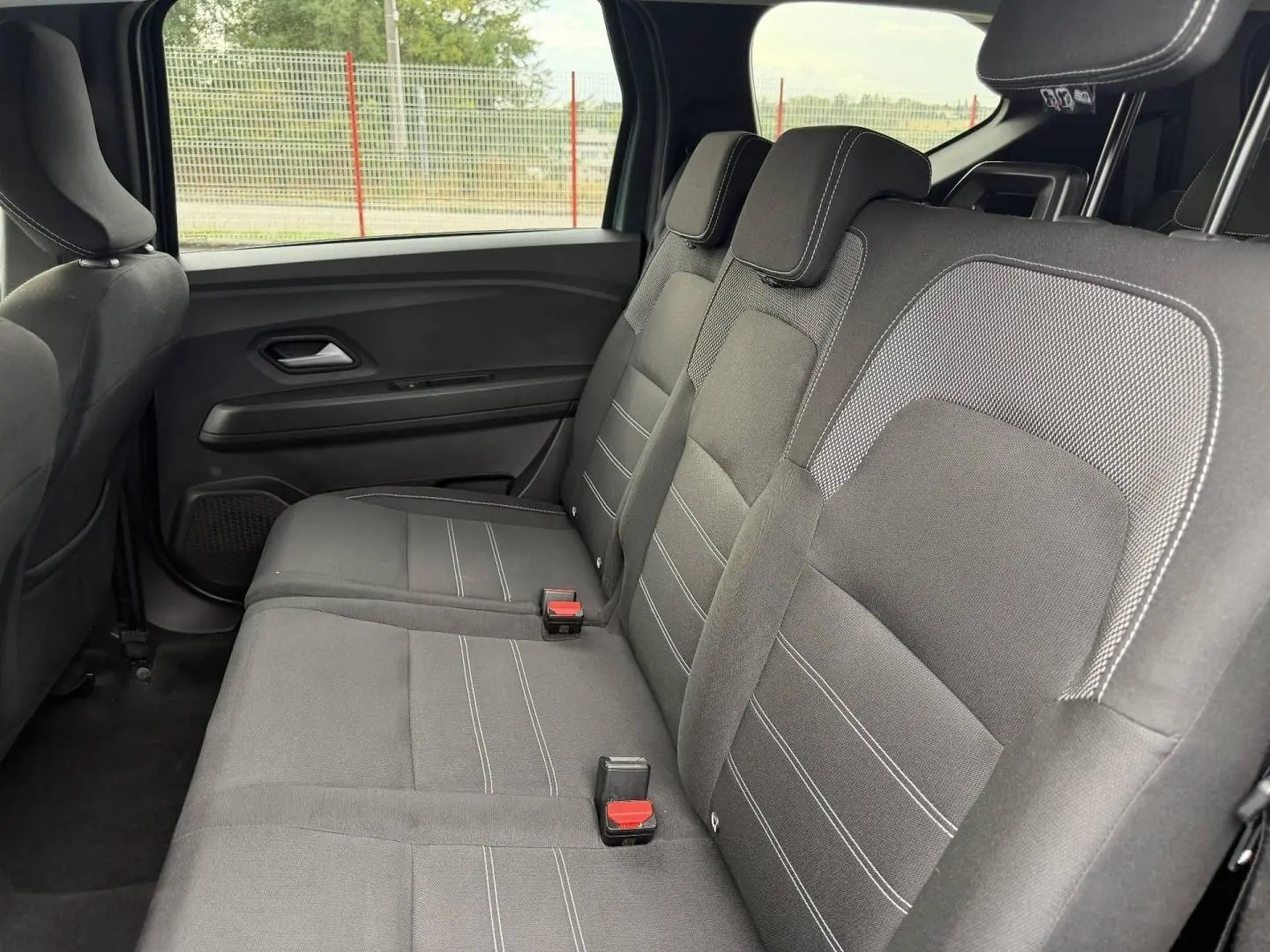 Vue latérale intérieure sur la banquette arrière noire avec appuie-têtes du Dacia Jogger 2025.