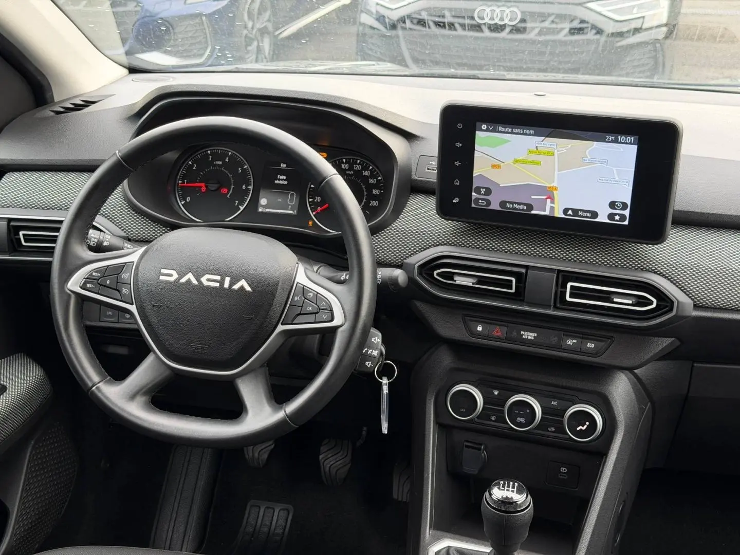 Vue intérieure du tableau de bord et volant noir du Dacia Jogger 2025 avec écran tactile et commande manuelle.