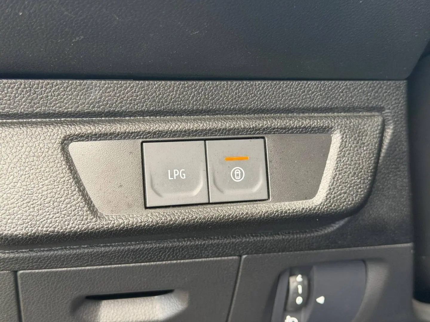 Gros plan sur les boutons LPG et verrouillage centralisé dans l’habitacle noir du Dacia Jogger 2025.