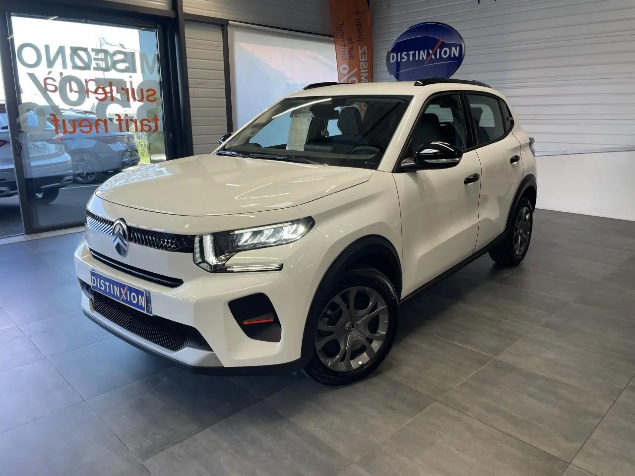 Citroën C3 blanc Banquise en 3/4 avant droit, avec barres de toit noires brillantes et jantes 17" Azurite.
