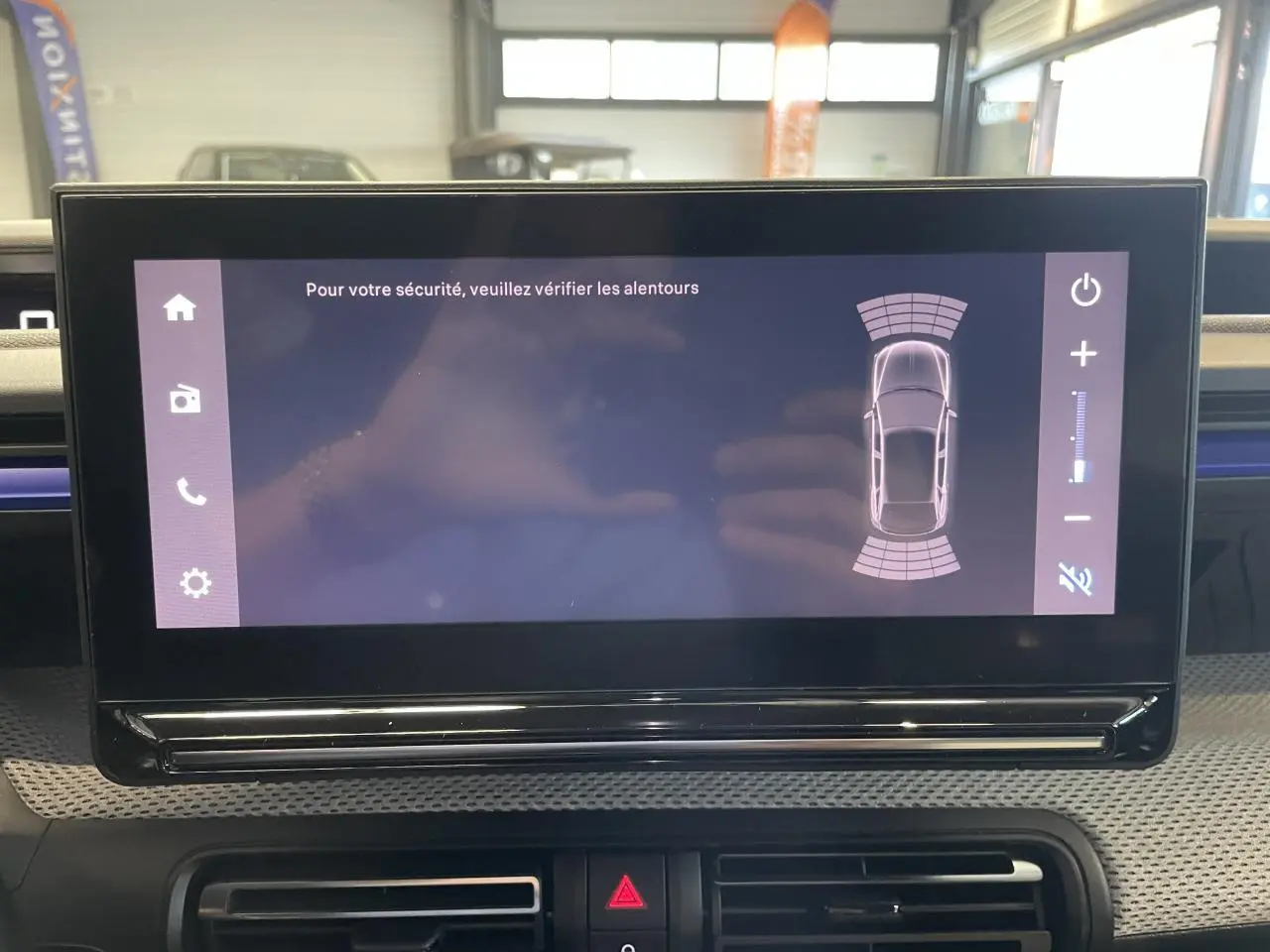 Écran tactile central affichant l'aide au stationnement dans l'habitacle d'une Citroën C3 blanche.