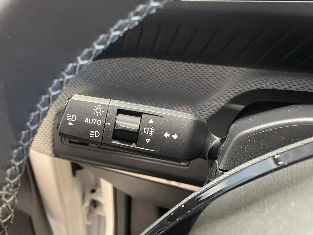 Gros plan sur la commande des feux et clignotants à gauche du volant dans l’habitacle d’une Citroën C3 blanche 2025.