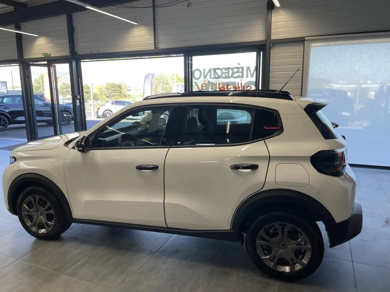 Citroën C3 blanc vue de profil côté gauche, avec barres de toit noir brillant et jantes 17 pouces Azurite.