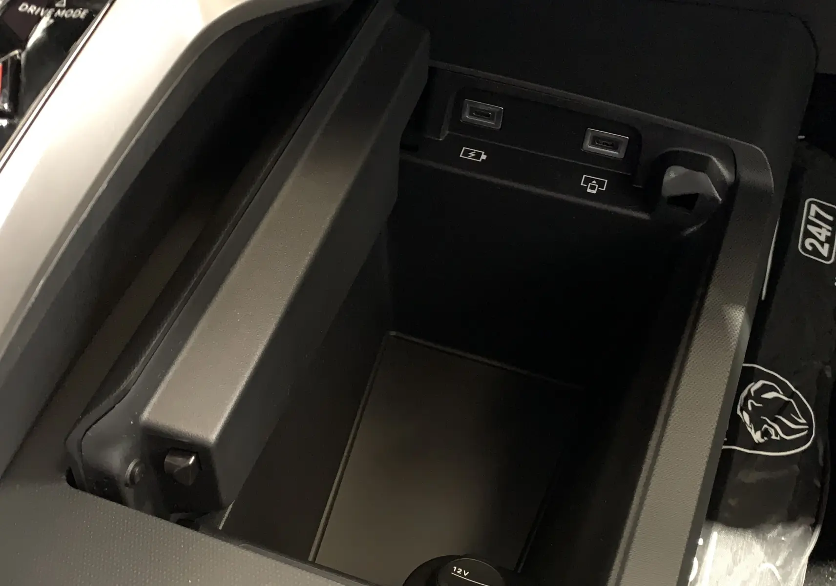 Vue rapprochée de la console centrale du Peugeot 3008 III GT Hybrid 136 e-DSC6 avec prises USB et prise 12V visibles.