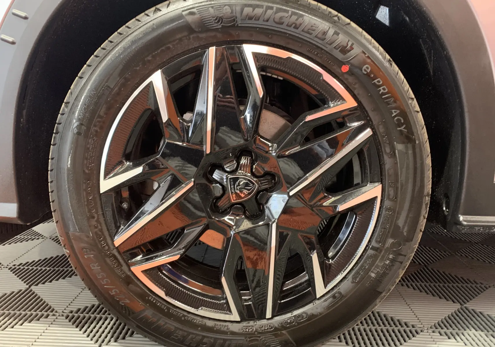 Gros plan sur la jante noire et argentée du côté gauche du Peugeot 3008 III GT HYBRID 136 e-DSC6 gris Artense.