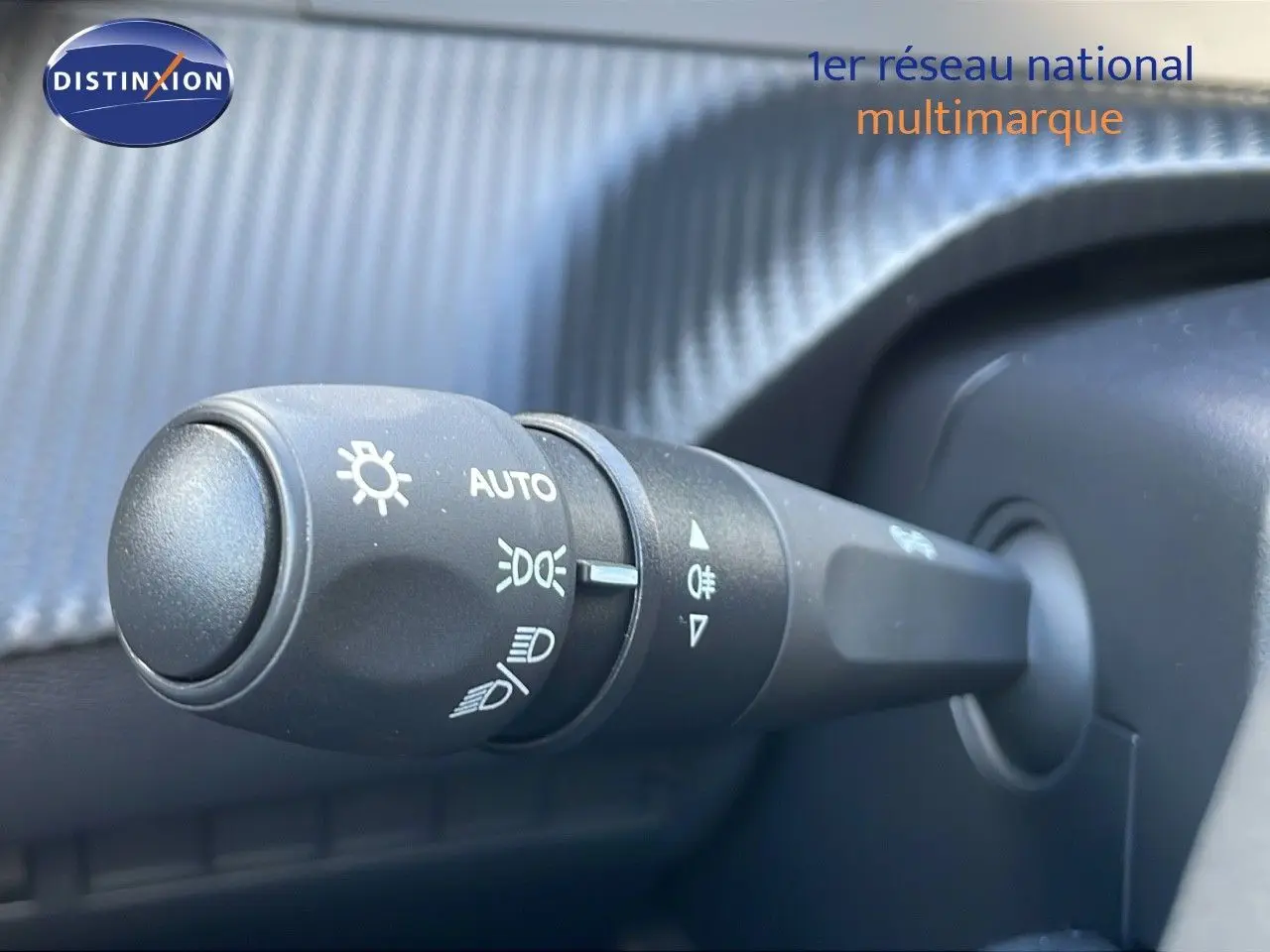 Gros plan sur la commande des phares du Peugeot 2008 gris Artense, montrant les réglages automatiques et feux antibrouillard.