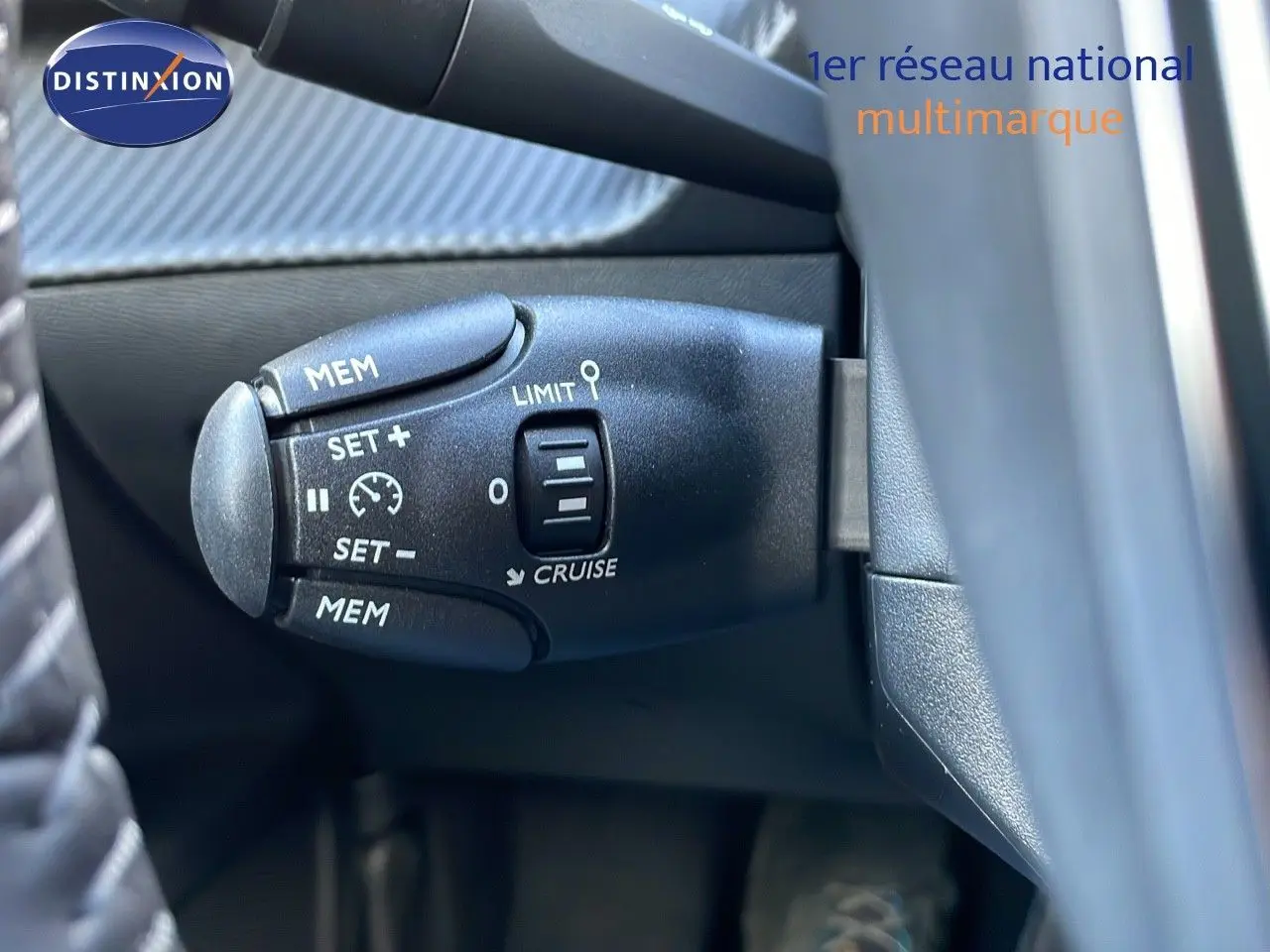 Gros plan sur la commande de régulateur de vitesse du Peugeot 2008 gris Artense métal, côté gauche du volant.