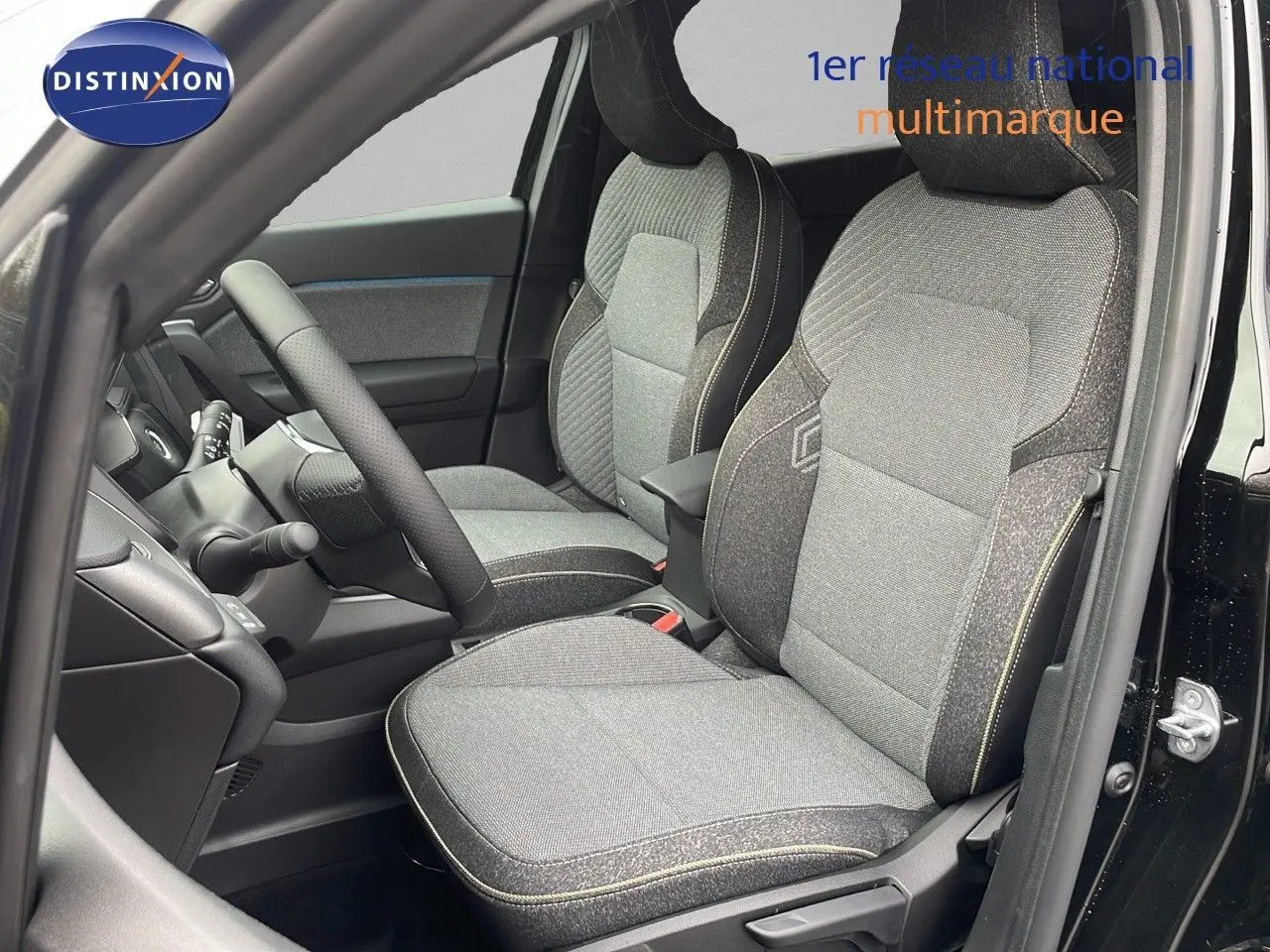 Intérieur du Renault Captur E-Tech hybride 2025, vue côté conducteur sur sièges tissu gris et noir dans porte ouverte noire.