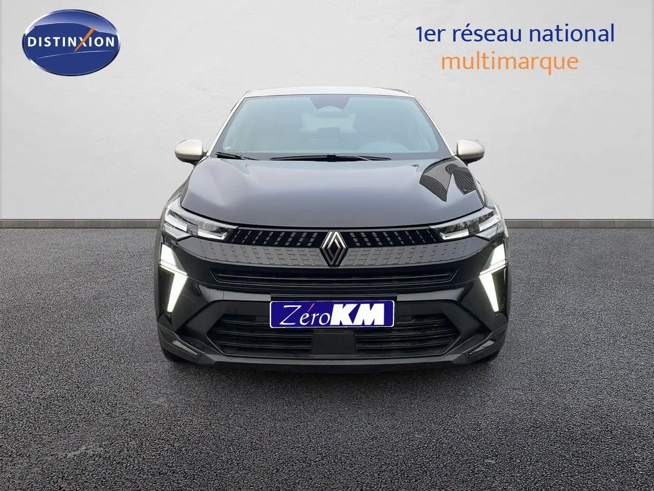 Vue frontale d'un Renault Captur E-Tech hybride noir étoile métal avec toit beige et feux LED allumés.