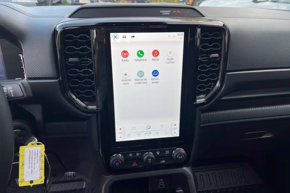 Vue intérieure centrée sur l'écran tactile vertical du Ford Ranger 2025 avec commandes climatisation et tableau de bord noir.