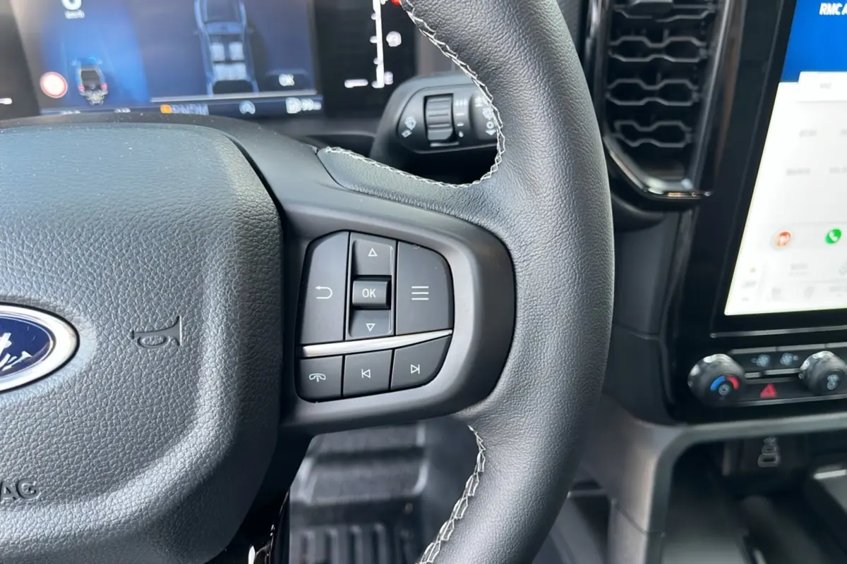 Gros plan sur le volant cuir multifonctions et l'écran tactile du tableau de bord du Ford Ranger 2025.