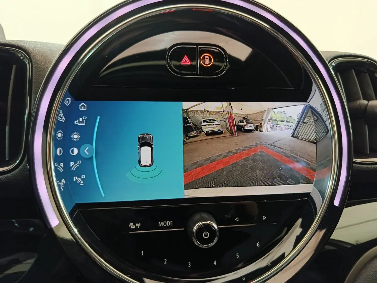 Écran tactile rond affichant la caméra de recul et capteurs de stationnement dans un MINI Countryman blanc 2021.