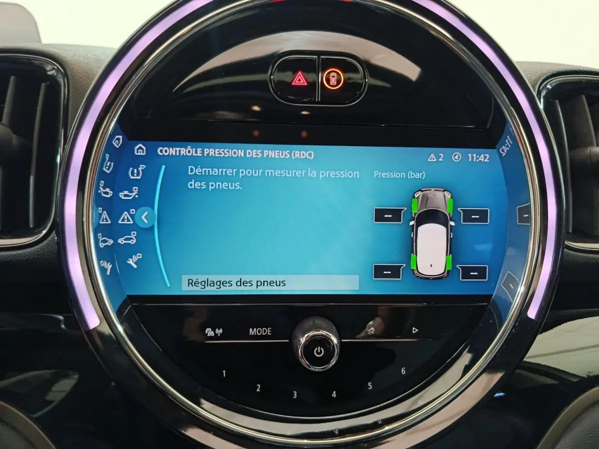 Écran tactile circulaire du tableau de bord du MINI Countryman blanc, affichant le contrôle pression des pneus.