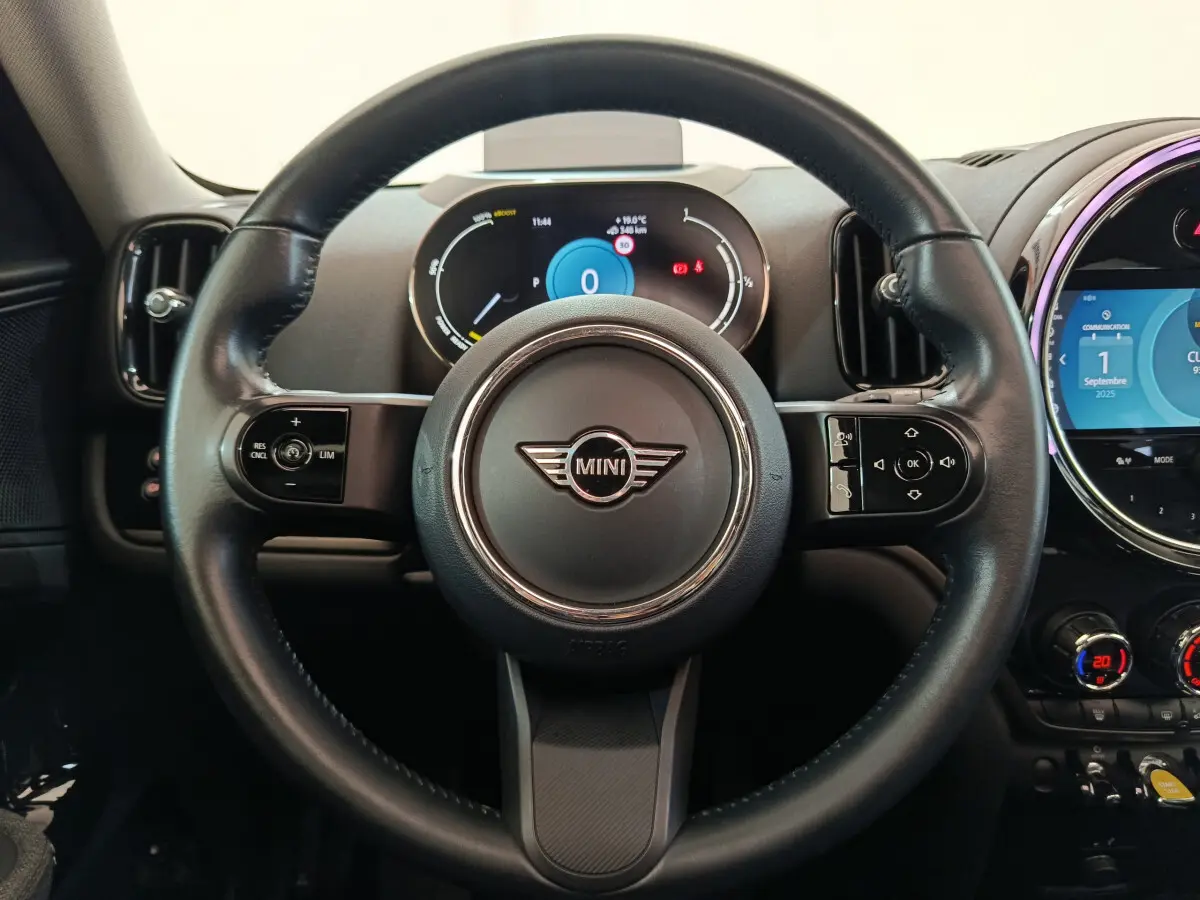Vue centrée sur le volant cuir noir du MINI COUNTRYMAN 2021 avec tableau de bord numérique et écran tactile rond.