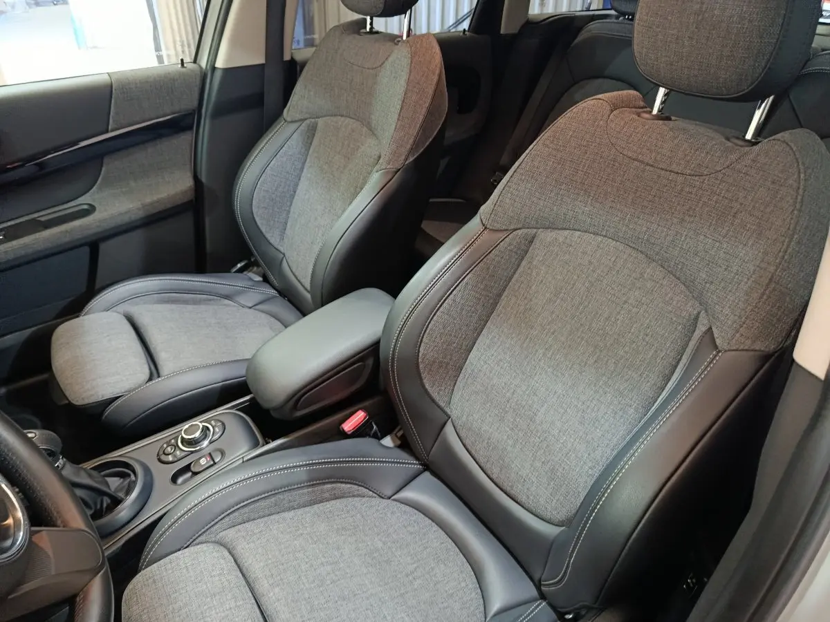 Vue intérieure rapprochée des sièges avant en tissu gris et cuir noir du MINI Countryman Cooper SE 2021.