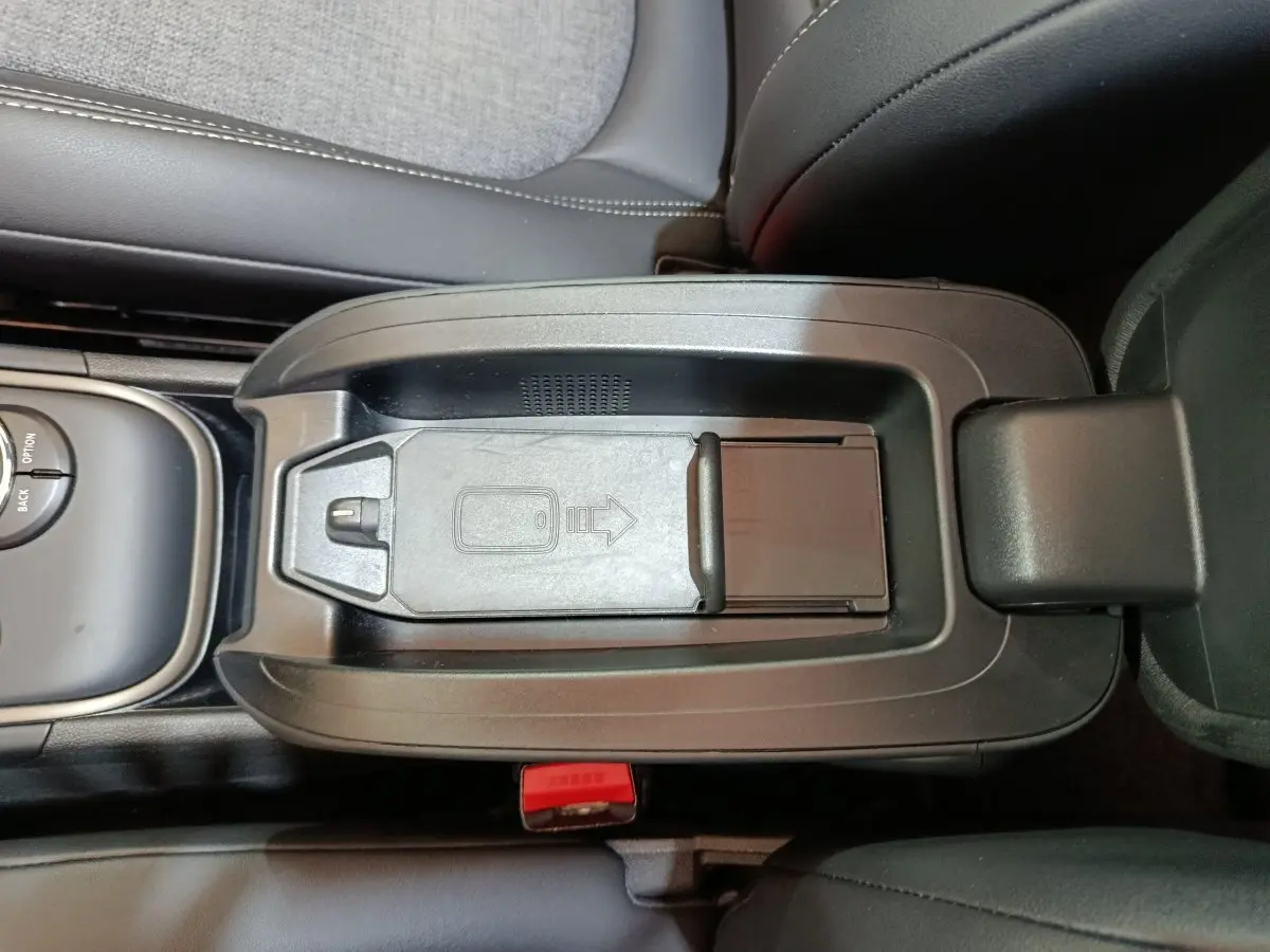 Vue rapprochée de la console centrale noire du MINI COUNTRYMAN hybride avec rangement et molette de commande.