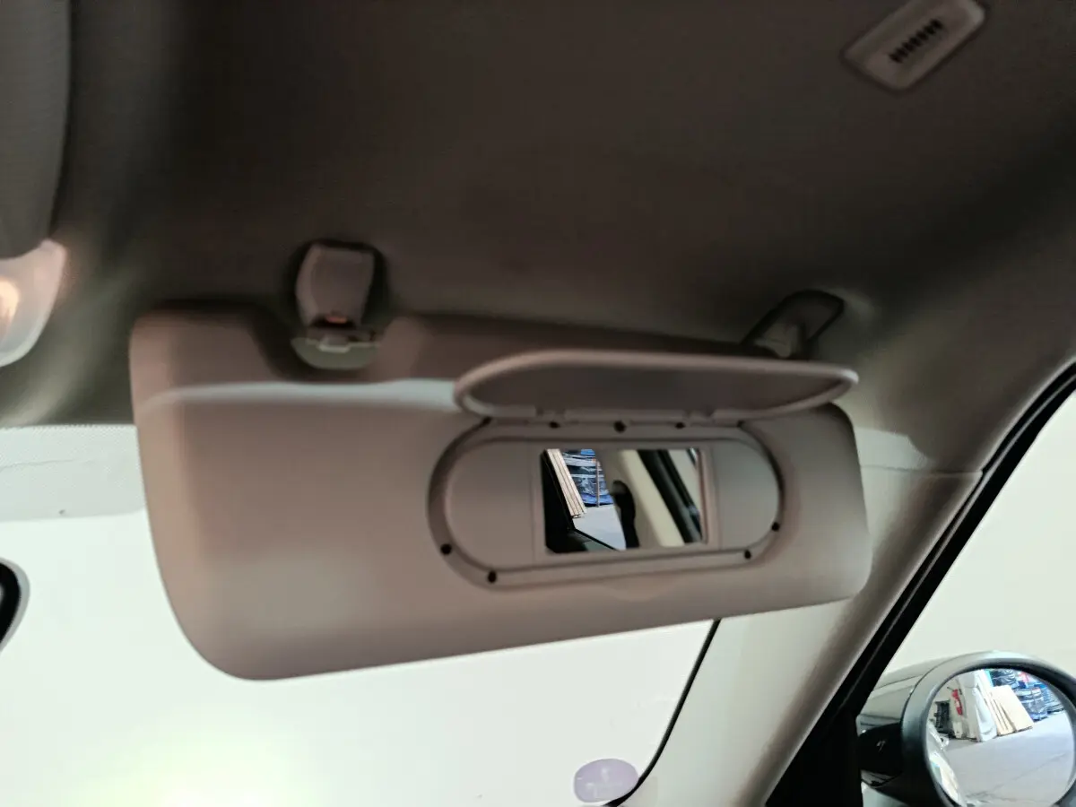 Miroir de courtoisie ouvert côté droit dans l'habitacle d'un MINI Countryman blanc, vue rapprochée intérieure.