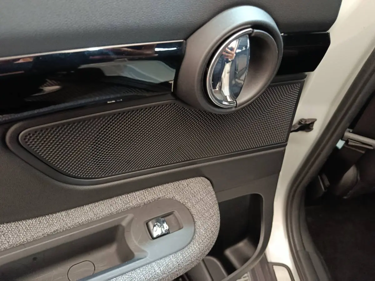 Poignée intérieure côté droit avec garniture noire et grise du MINI Countryman Cooper SE blanc, vue de l'arrière passager.