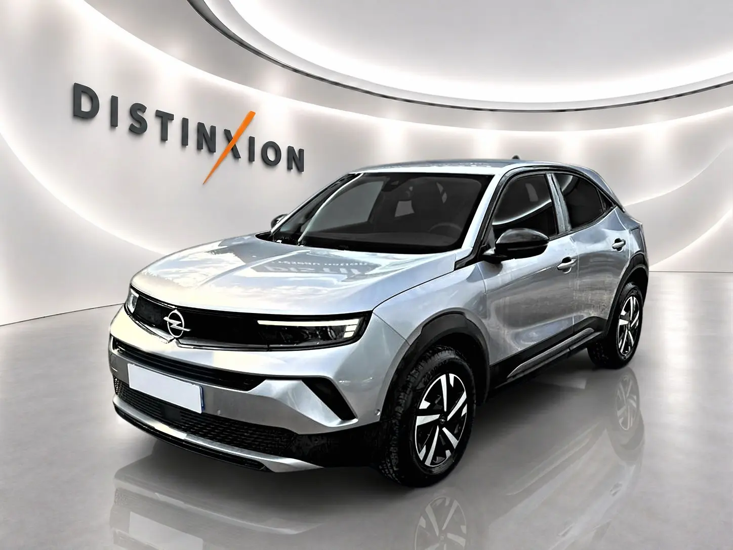 Opel Mokka gris en 3/4 avant droit, avec jantes noires et détails noirs contrastants sur carrosserie.
