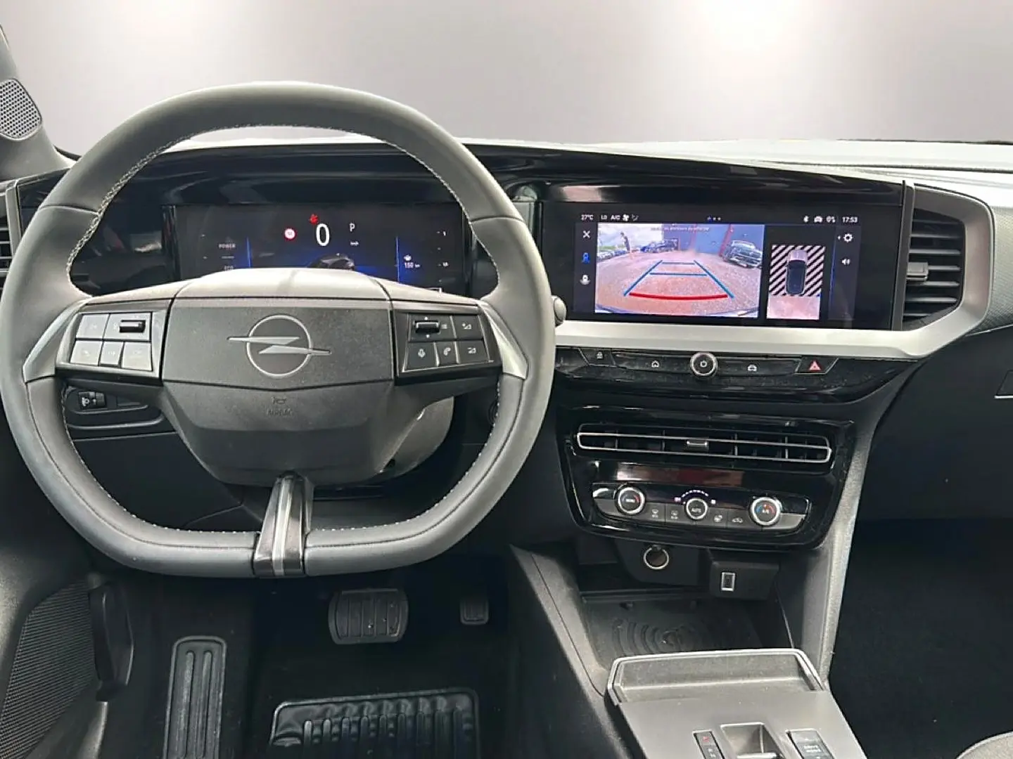 Vue intérieure frontale du tableau de bord gris de l'Opel Mokka 2025 avec écran tactile et volant multifonction.