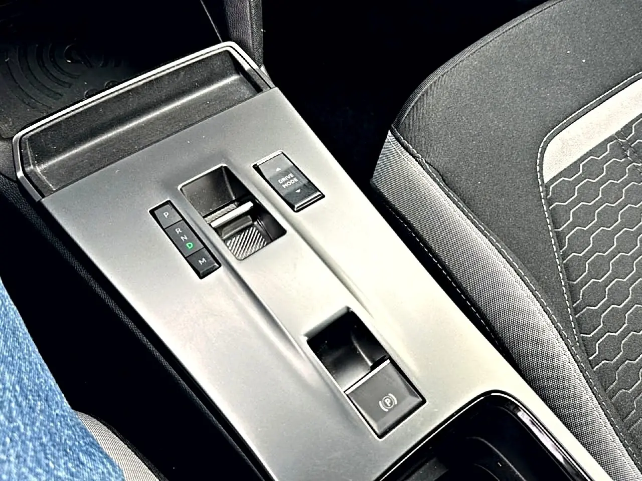 Vue rapprochée de la console centrale grise avec levier de vitesse automatique et siège tissu noir Opel Mokka 2025.
