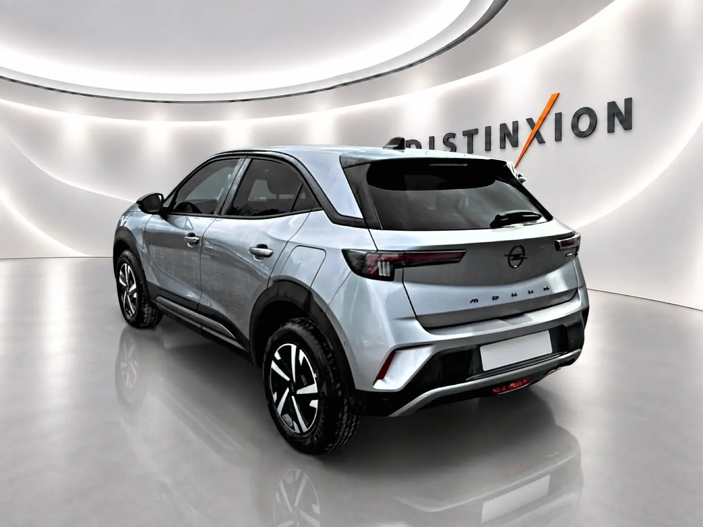 Opel Mokka gris en 3/4 arrière droit, avec feux arrière LED et jantes noires à motifs argentés.