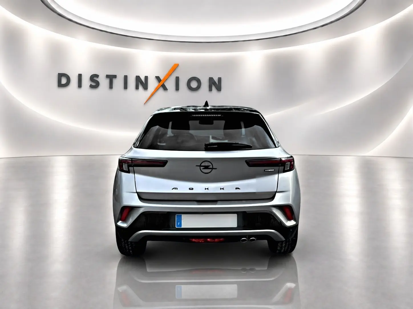 Vue arrière d'un Opel Mokka gris 2025 avec feux LED fins et double sortie d'échappement visible en studio.