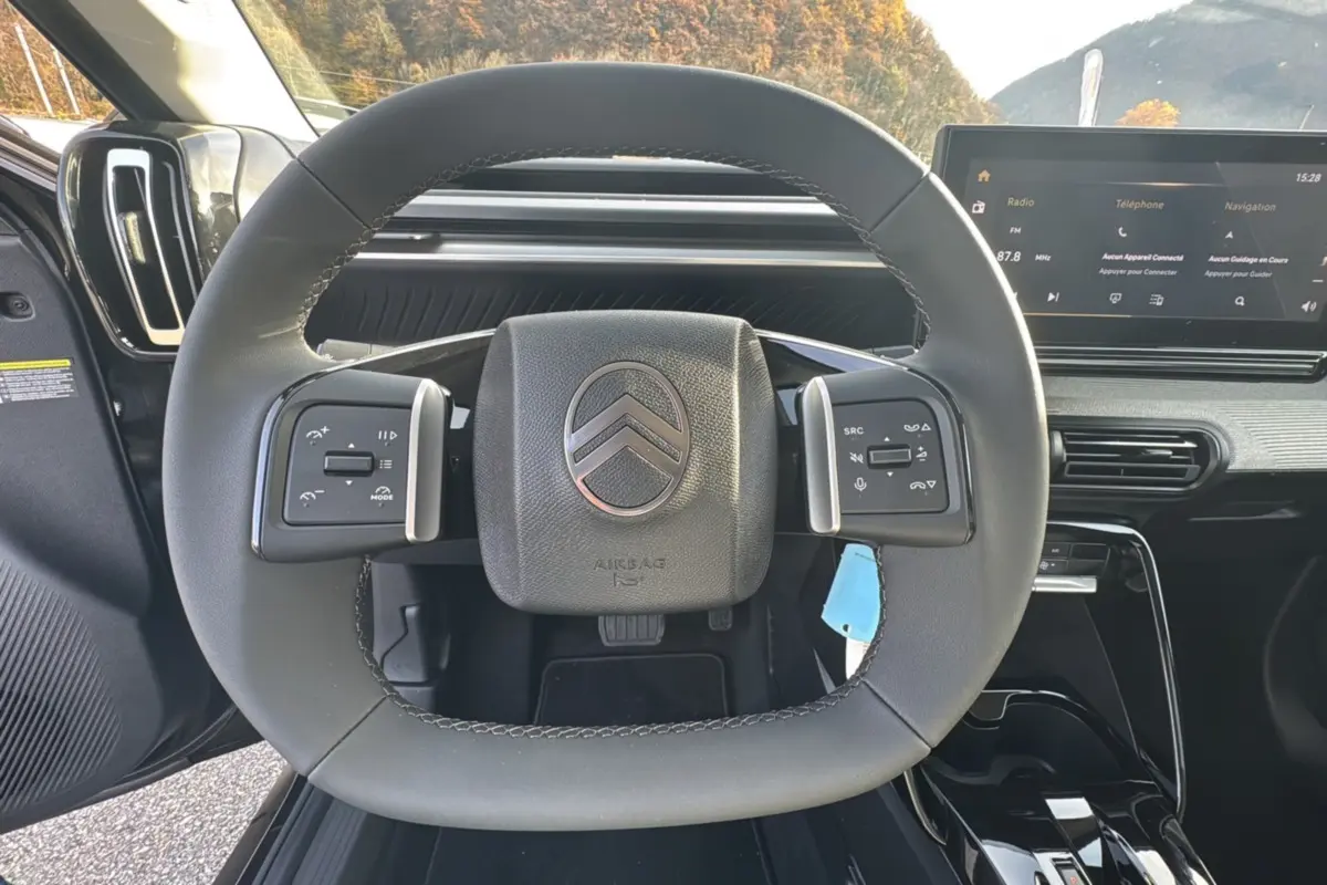 Volant cuir noir multifonctions de la Citroën C3 Aircross Hybrid 145 avec écran tactile et tableau de bord moderne.