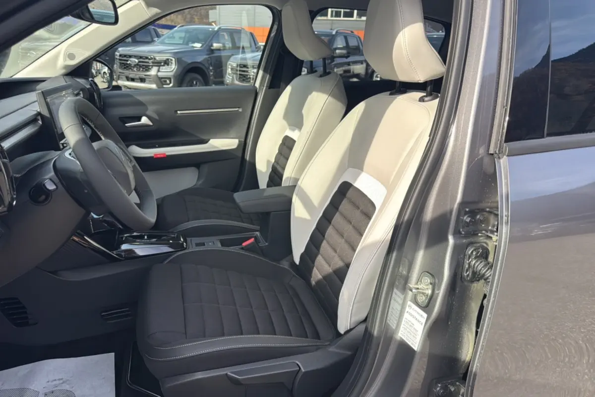 Vue intérieure côté gauche montrant les sièges bi-ton beige et noir du Citroën C3 Aircross gris mercury toit noir.