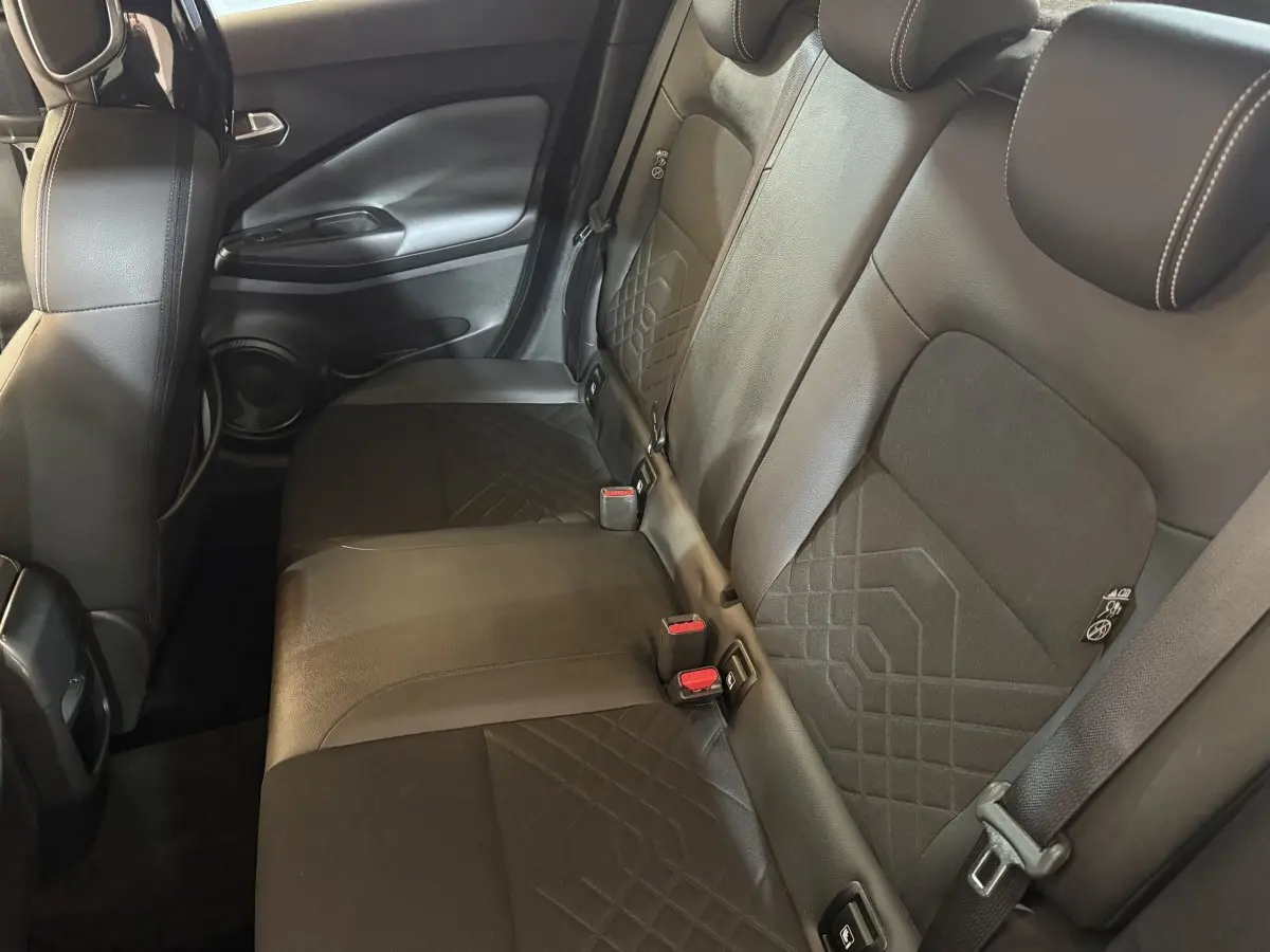 Vue intérieure sur la banquette arrière noire du Nissan Juke 2021, avec détails de coutures et ceintures visibles.
