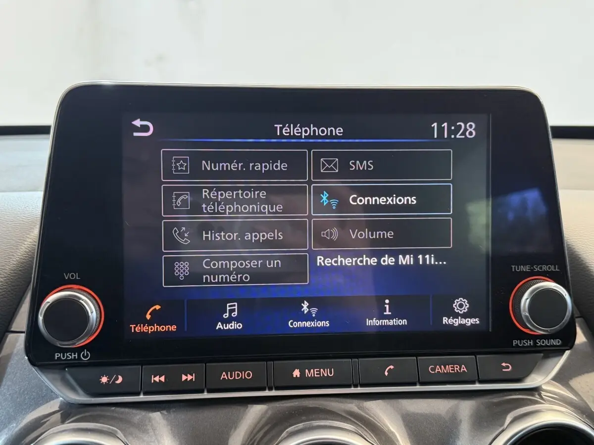 Écran tactile central du Nissan Juke Tekna 2021 affichant le menu téléphone avec commandes physiques en dessous