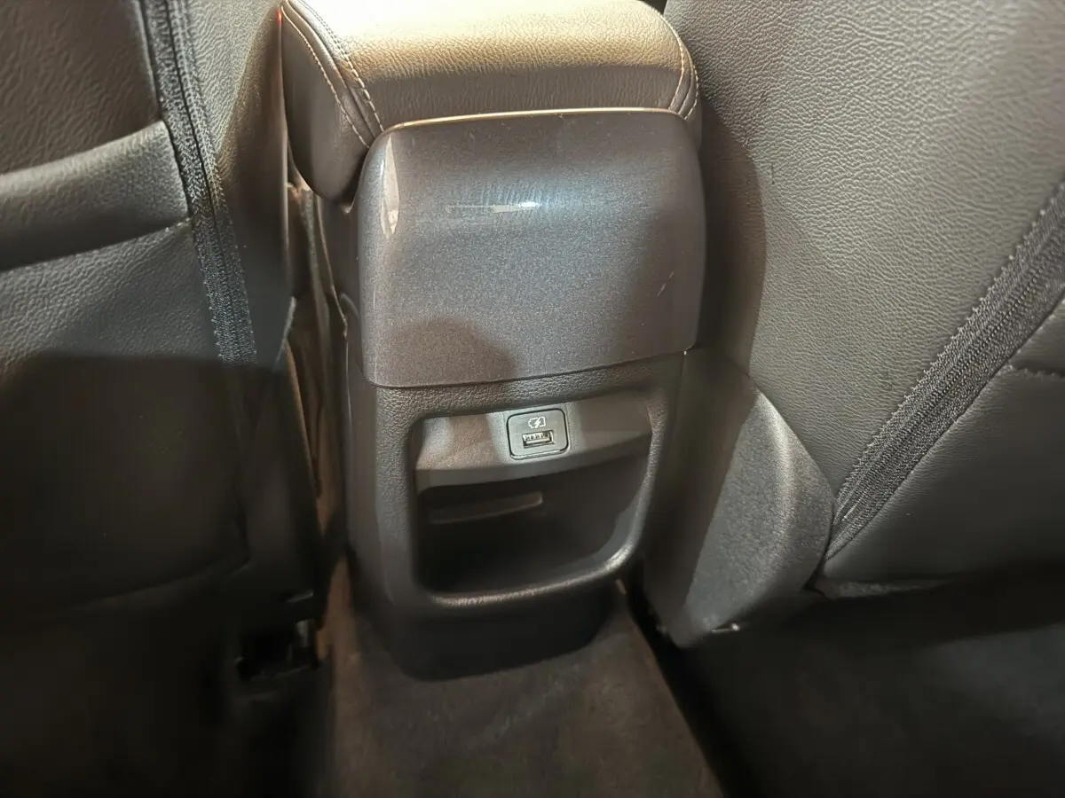 Prise USB arrière intégrée sous l'accoudoir central des sièges noirs du Nissan Juke gris clair 2021 Tekna.