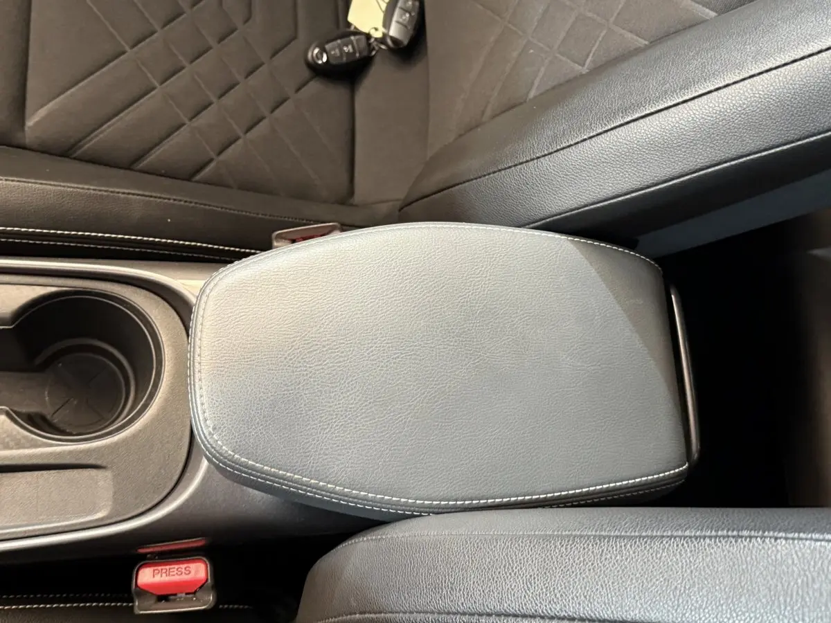 Accoudoir central en cuir gris avec surpiqûres blanches et porte-gobelet dans Nissan Juke Tekna 2021.