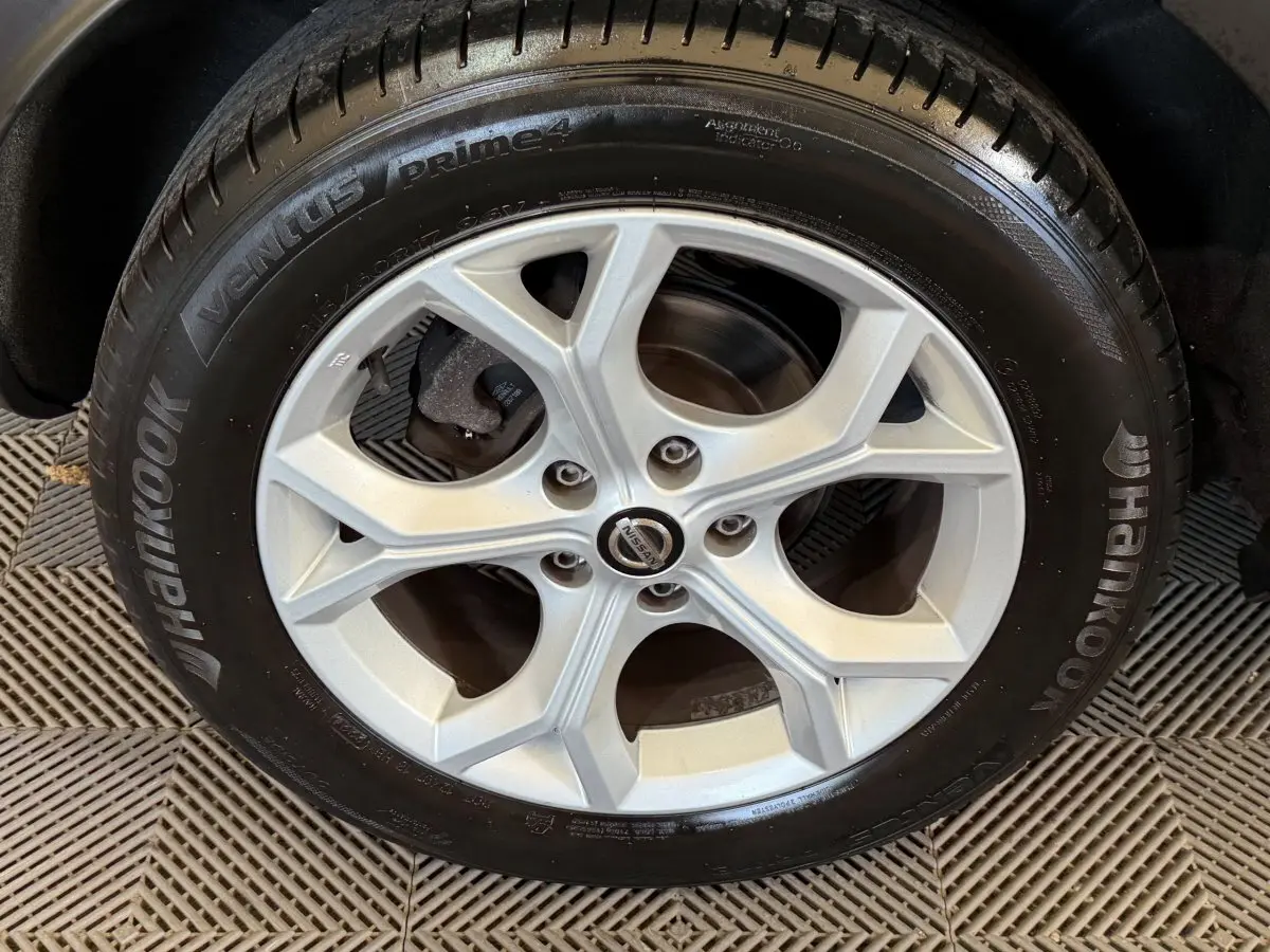 Vue rapprochée sur la roue arrière droite du Nissan Juke gris clair, mettant en valeur le pneu Hankook et la jante.