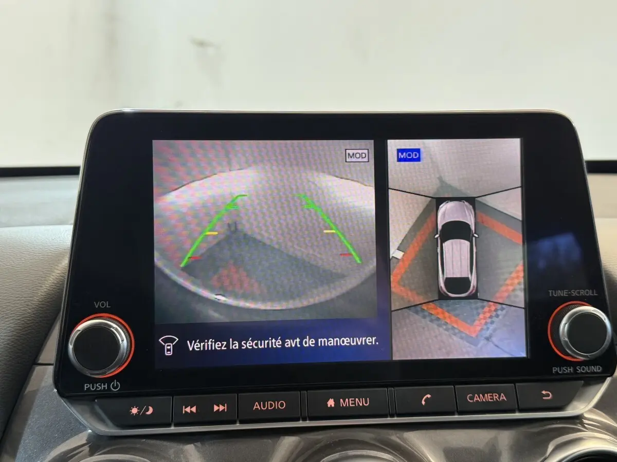 Écran tactile du Nissan Juke Tekna 2021 montrant la caméra 360° d'aide au stationnement en vue arrière et vue du dessus.